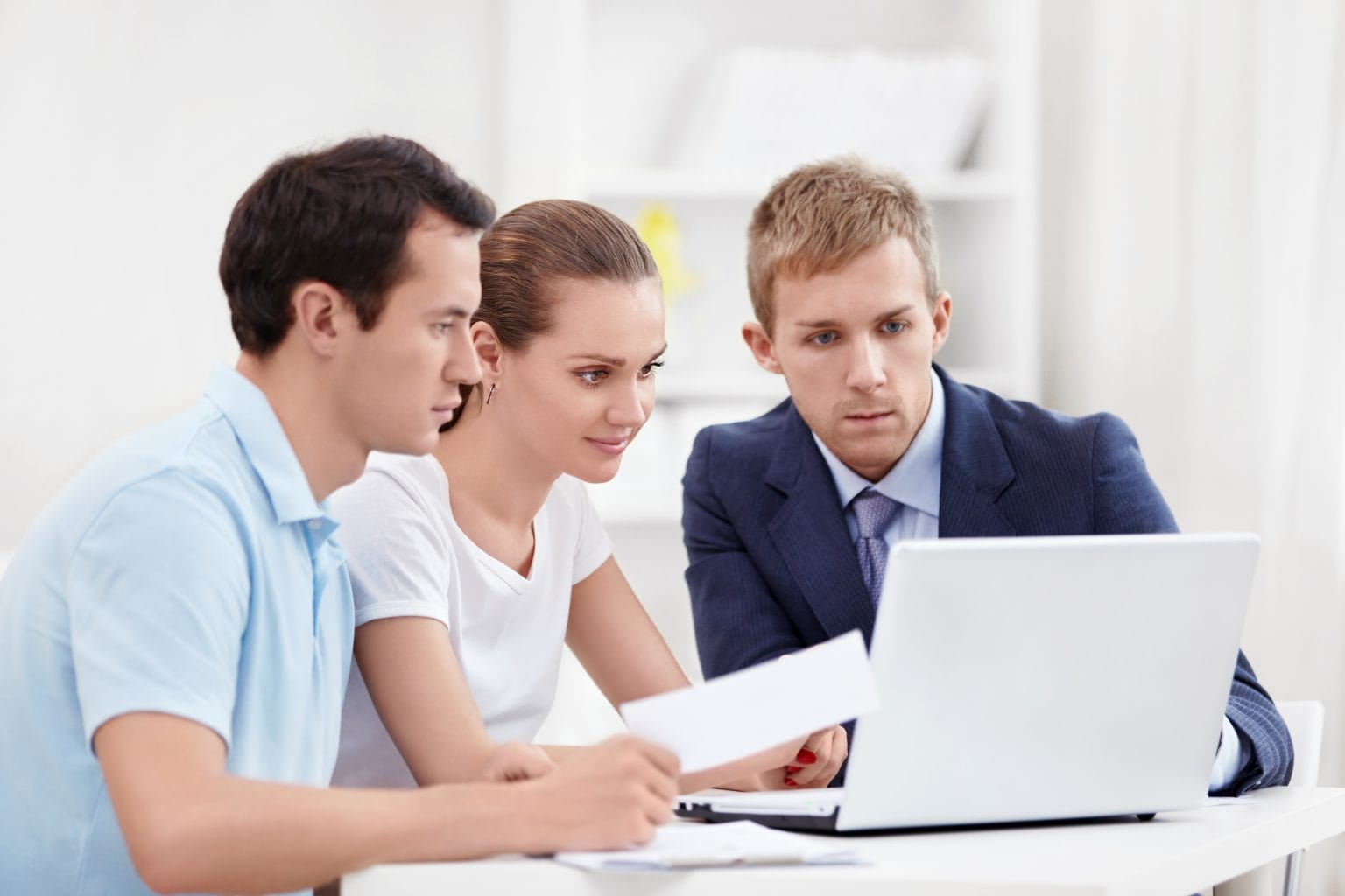 A couple going through their options with an adviser at a laptop